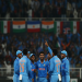 Indian Under-19 cricket team celebrating a wicket during an ICC U19 Cricket World Cup match in a packed stadium.